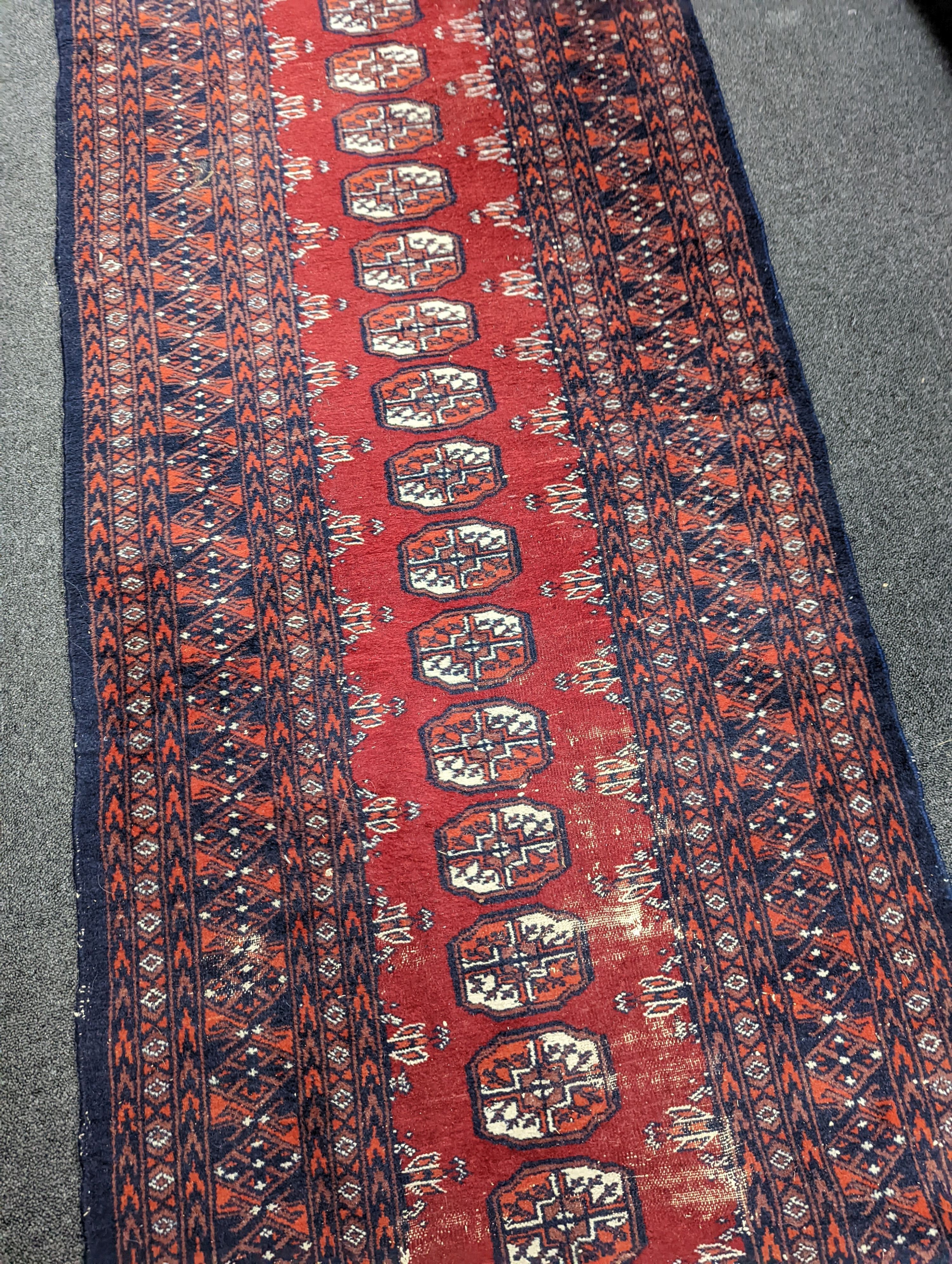 A Caucasian red ground rug and a Bokhara runner, rug 180 x 120 cms